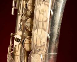 Toneking tenor #28034. Source: Randy Cole on reverb.com vintage German saxophone, Julius Keilwerth, Toneking, saxophone keys, angel wing key guard made of Lucite, silver plated horn against dark red background