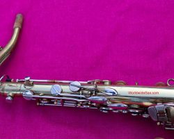 U.S. Bandmaster Tenor # 112xx D&J copy of The New King. Source: WWS vintage German tenor saxophone, Dörfler & Jörka, U.S. Bandmaster, stencil sax, left palm & pinkie keys, neck in socket, round thumb screw holds neck in place, two-tone tenor on purplish background