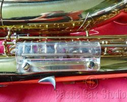 Toneking alto #286XX. Source: Bassic Sax vintage German saxophone, Julius Keilwerth, Toneking, original Lucite clothes guard, lacquer horn on red background