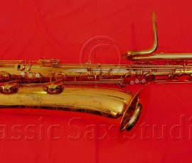 H. Couf Superba I bass # 871xx gold lacquer bass sax on red background, H. Couf Superba I, German sax, Julius Keilwerth-made saxophone