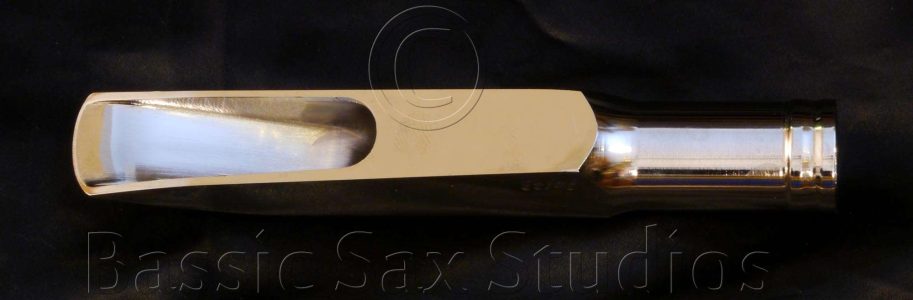 Fred Lebayle Rosie bass sax M/P. Photo by H. Kahlke Fred Lebayle Rosie Bass Saxophone Sax Mouthpiece, table view, metal mouthpiece, handmade mouthpiece, chamber, side rails, tip rail, baffle, window