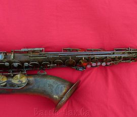 King Zephyr by H.N. White # 307xxx naturally delacqured brass tenor saxophone on red background, H.N. White King Zephyr,
