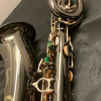 Serial # 013266. Source: Cliff's Gear Outlet on reverb.com low A bari sax, Dave Guardala Artist Series baritone saxophone, floral engraving, black nickel plated with silver plated keys, B&S