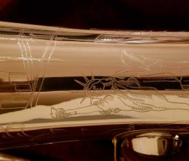 Source: adbforyour on eBay.com DG-502 tenor sax, New York Series, series features NY skyline features engraved all over the keywork & bell, rich engraving all over the instrument, Dave Guardala tenor saxophone, silver plate with gold plated keys,