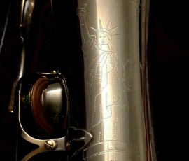 Source: adbforyour on eBay.com DG-502 tenor sax, New York Series, series features NY skyline features engraved all over the keywork & bell, rich engraving all over the instrument, Dave Guardala tenor saxophone, silver plate with gold plated keys,